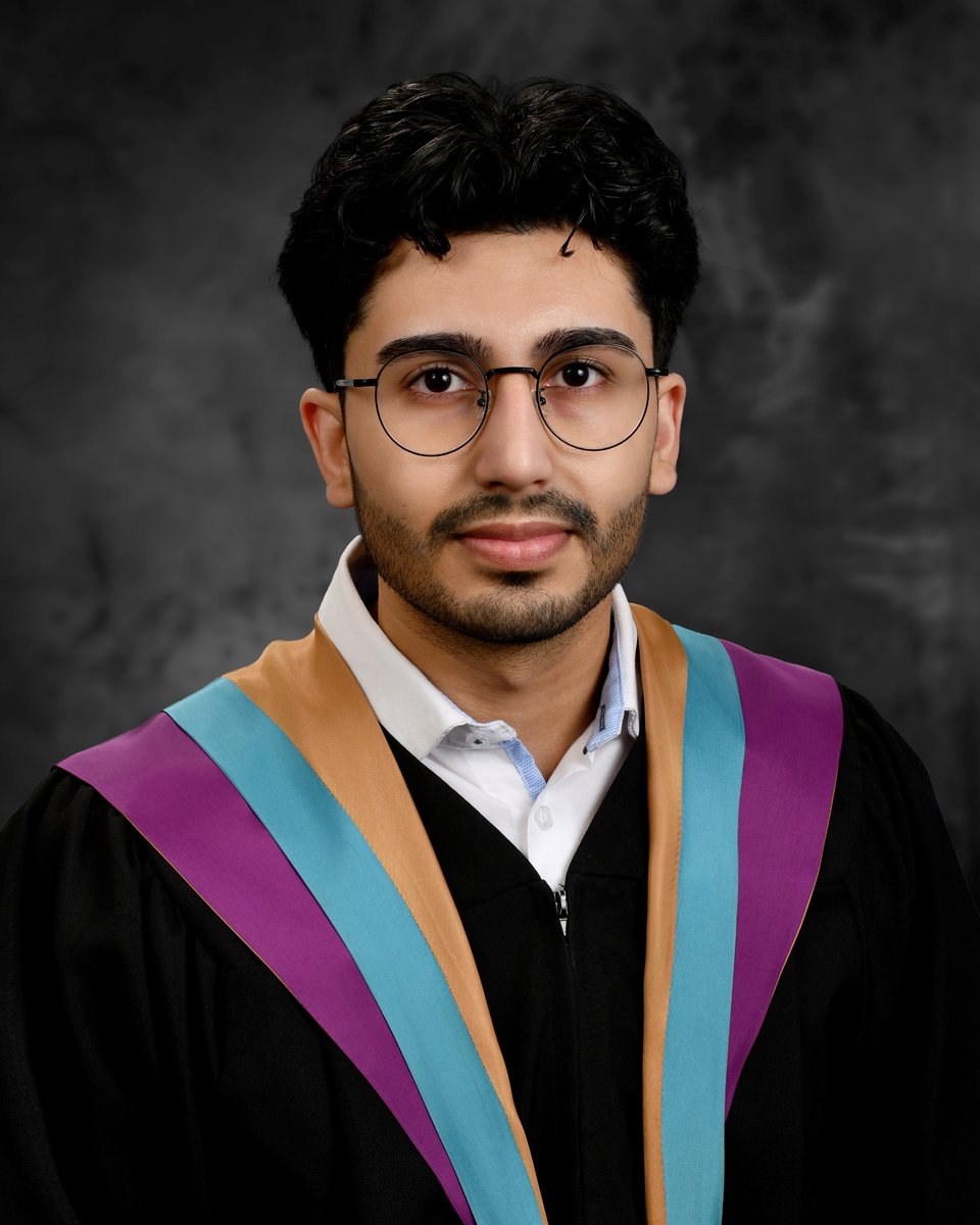 Shahzeb Atif in a black graduation gown with a purple, teal and gold hood